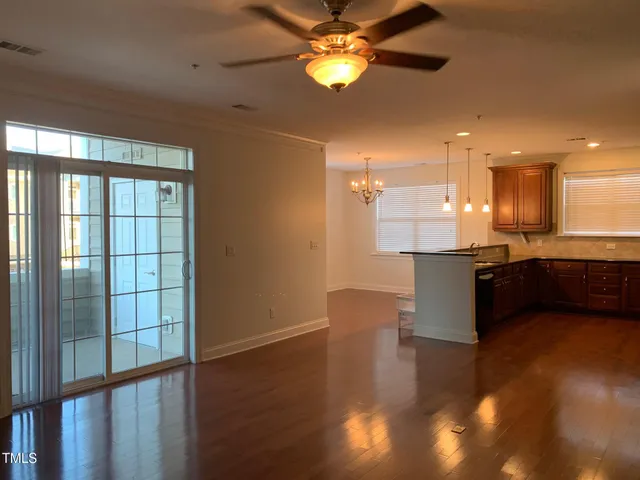 a kitchen with stainless steel appliances kitchen island granite countertop a refrigerator a sink and a large window