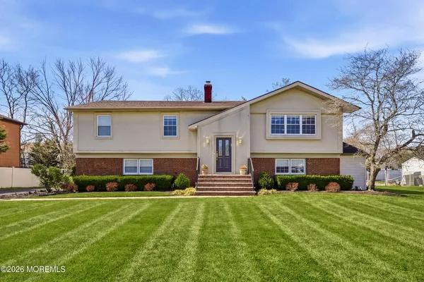 a front view of a house with a yard and trees