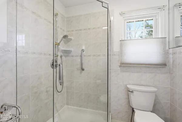 a bathroom with a toilet and a shower