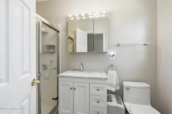 a bathroom with a granite countertop sink a toilet and a mirror