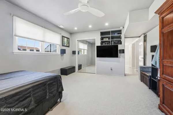 a bedroom with a large bed a flat tv screen and a walk in closet
