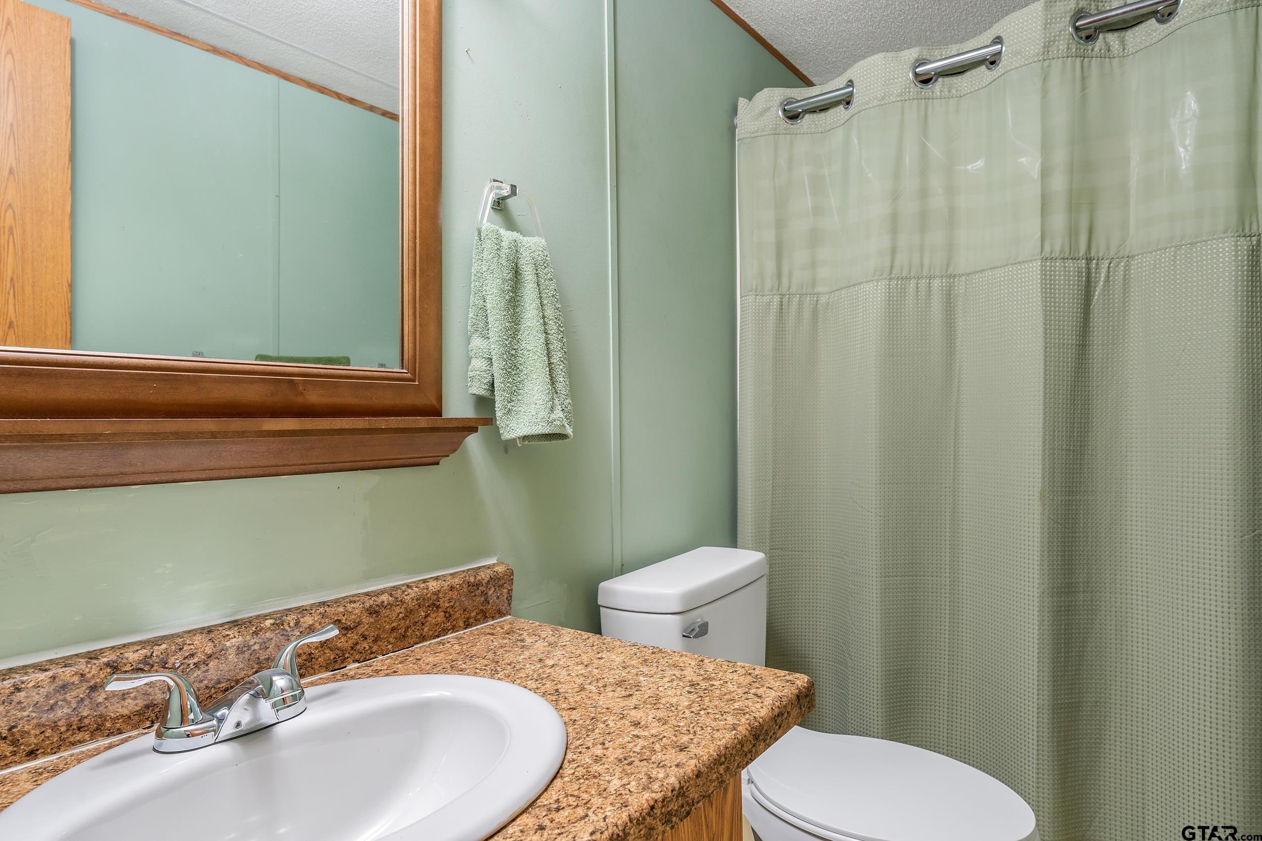 220 Broken Bow Quitman, TX 75783 - Photo 11 of 28 a bathroom with a sink and a mirror