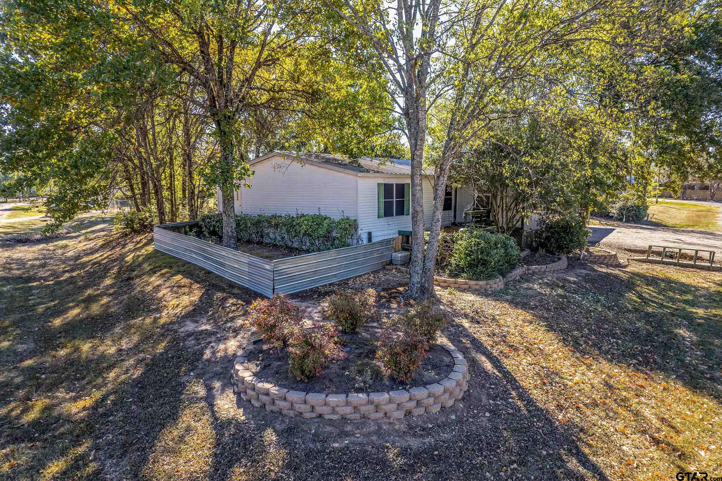220 Broken Bow Quitman, TX 75783 - Photo 2 of 28 a view of a backyard with large trees