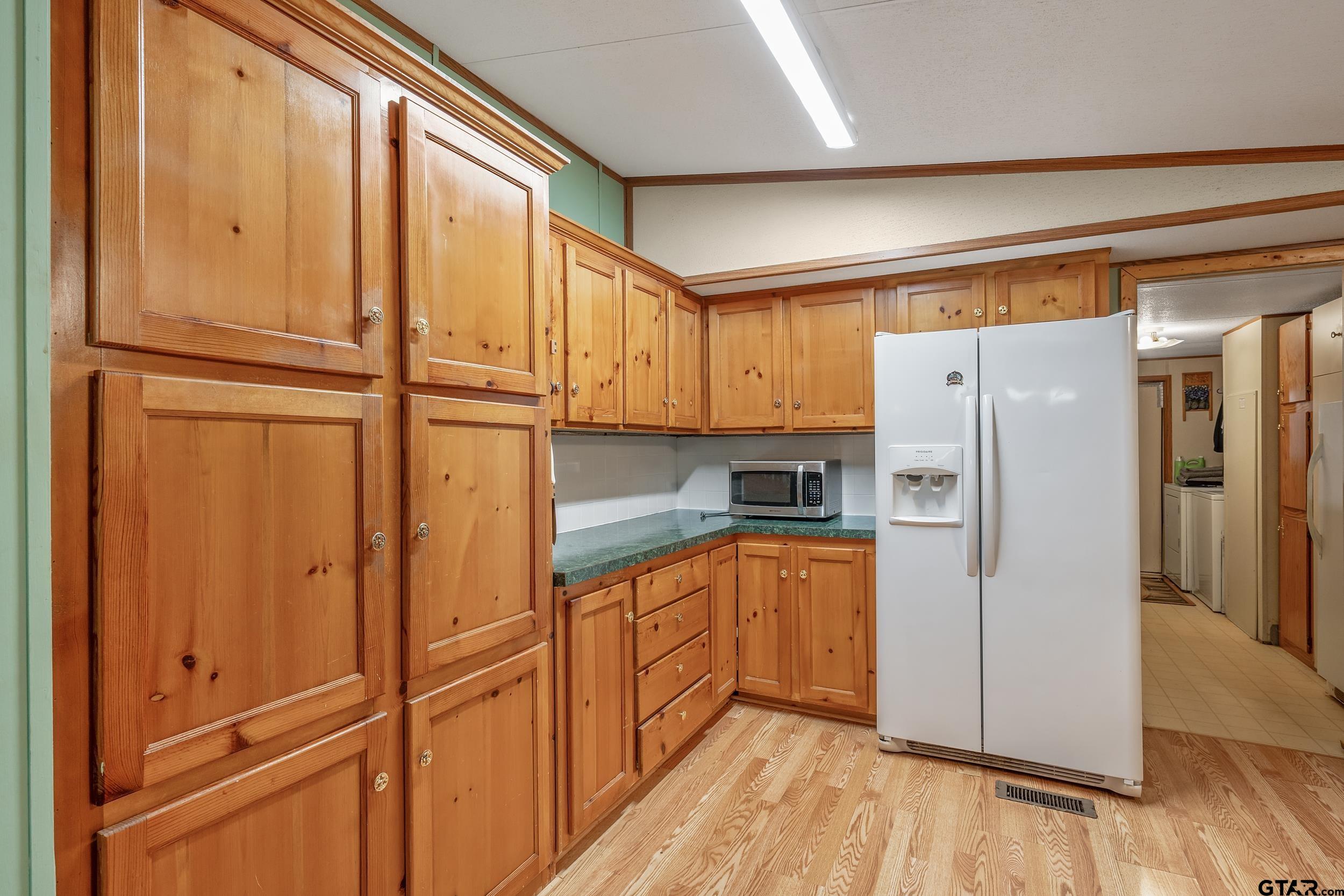 220 Broken Bow Quitman, TX 75783 - Photo 9 of 28 a kitchen with stainless steel appliances granite countertop a refrigerator a microwave and cabinets