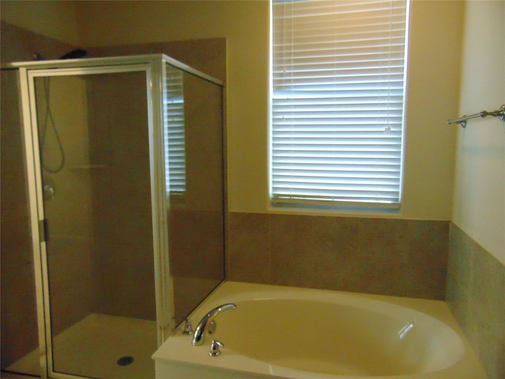 1076 Sanders Kyle, TX 78640 - Photo 11 of 12 a bathroom with a bathtub and a shower