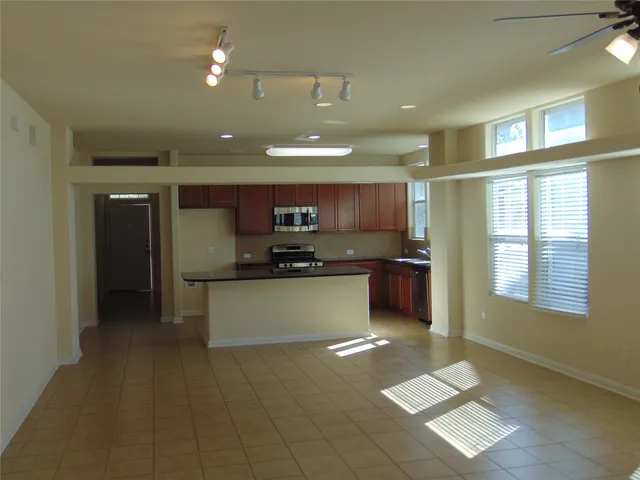 a large kitchen with a large counter top stainless steel appliances and a window
