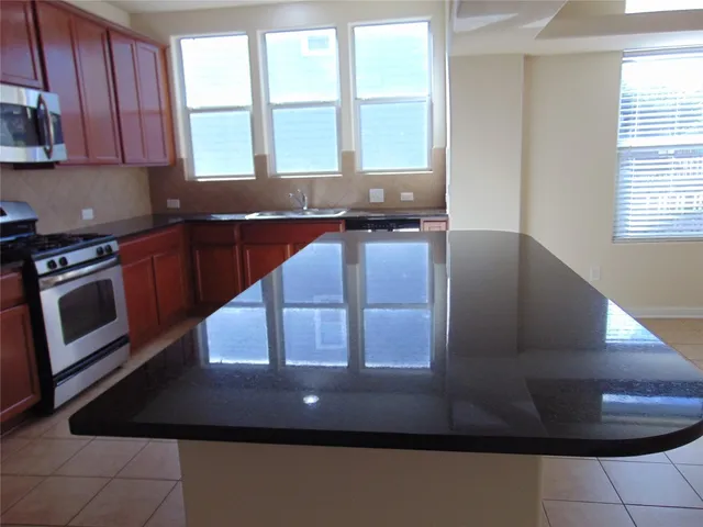 a kitchen with granite countertop wood cabinets and stainless steel appliances