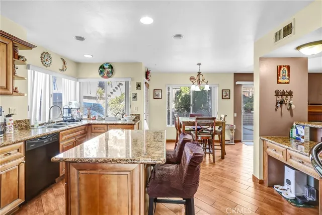 a dining hall with stainless steel appliances granite countertop a dining table chairs stove view and living room view