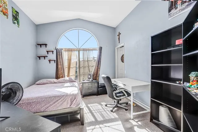 a bedroom with a bed a table and a window