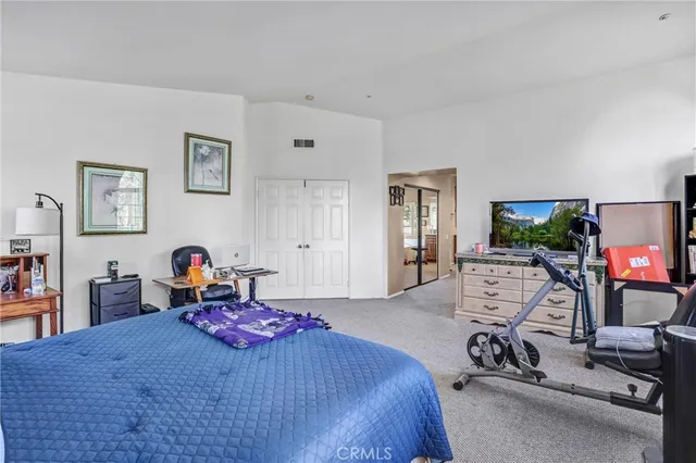 a bedroom with furniture a bed and a flat screen tv