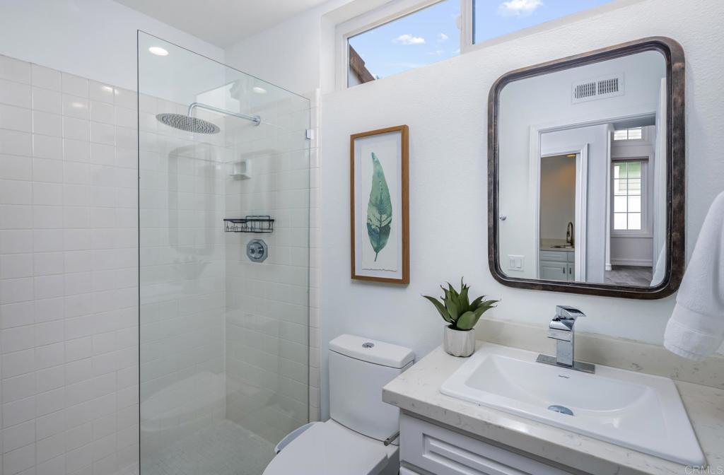 608 Crest Drive Encinitas, CA 92024 - Photo 24 of 32 a bathroom with a toilet a sink a shower and a mirror
