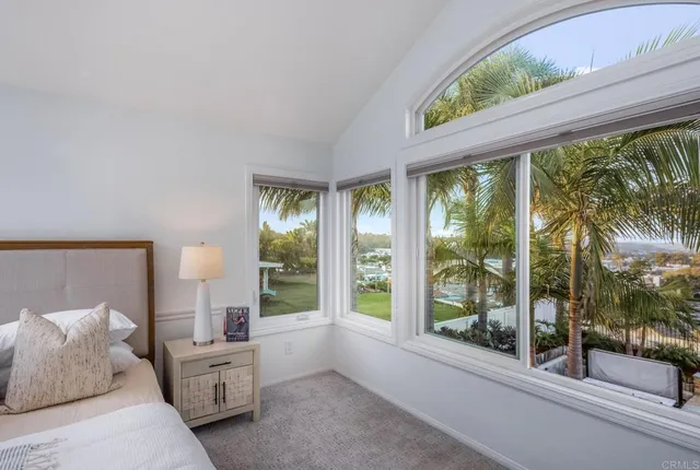 a bedroom with furniture and large windows