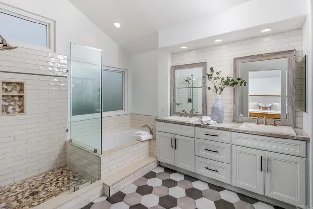 a bathroom with a double vanity sink a mirror and a bathtub