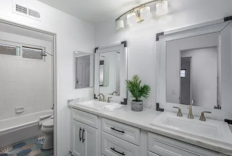 a bathroom with a double vanity sink toilet and shower