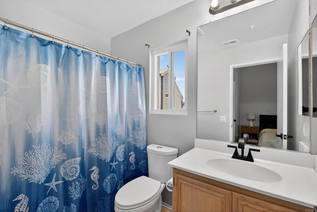 8927 Windham Court Spring Valley, CA 91977 - Photo 16 of 28 a bathroom with a sink a toilet a mirror and shower curtain