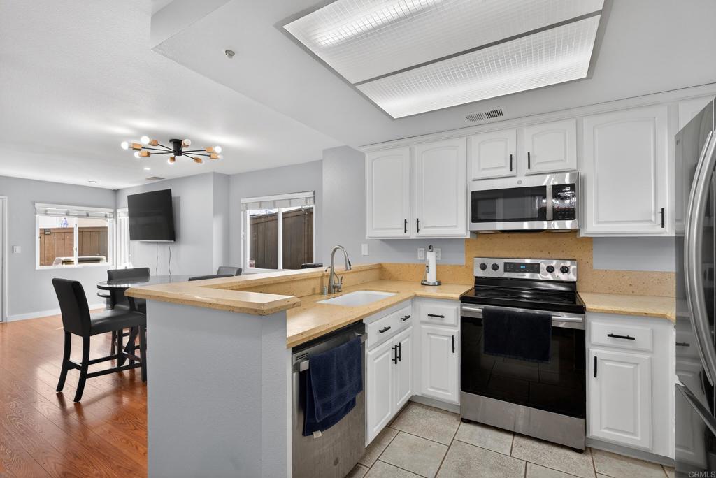 8927 Windham Court Spring Valley, CA 91977 - Photo 4 of 28 a kitchen with a stove sink and microwave