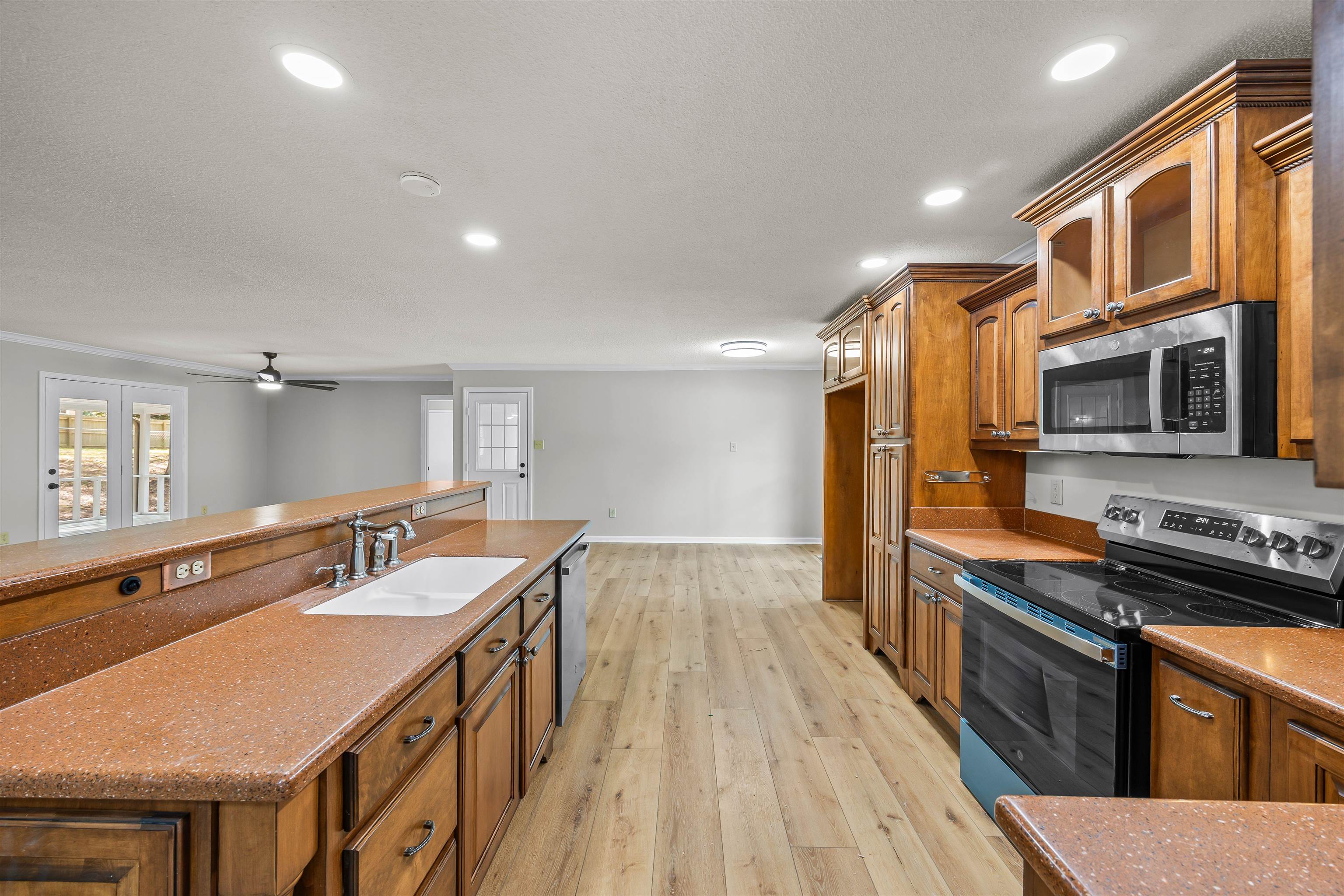 80 Pinewood Drive Jackson, TN 38305 - Photo 16 of 27 Kitchen with appliances with stainless steel finishes, brown cabinetry, light wood-type flooring, recessed lighting, and an island with sink