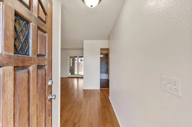 a view of a hallway with wooden floor and staircase