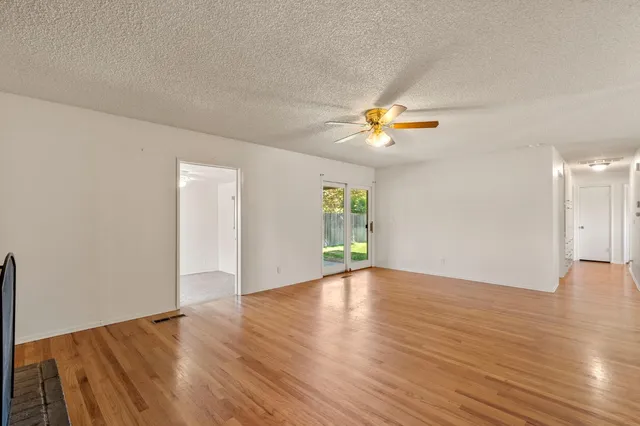 an empty room with wooden floor and a window