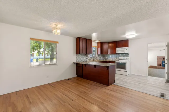 a kitchen with stainless steel appliances kitchen island granite countertop wooden cabinets a granite counter tops and a window