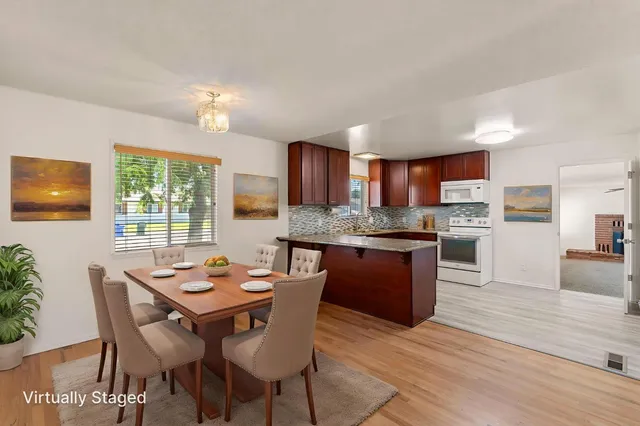 a kitchen with a dining table chairs and refrigerator