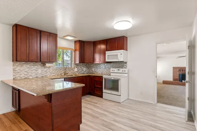 a kitchen with granite countertop cabinets stainless steel appliances and a counter space