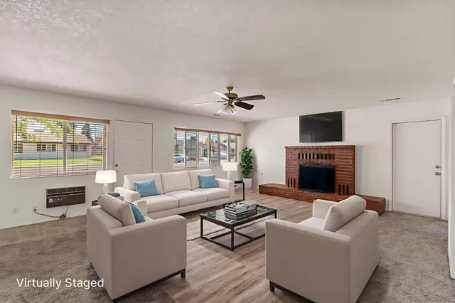 a living room with furniture a fireplace and a flat screen tv