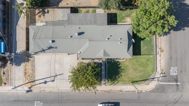 an aerial view of a house with a yard and large tree