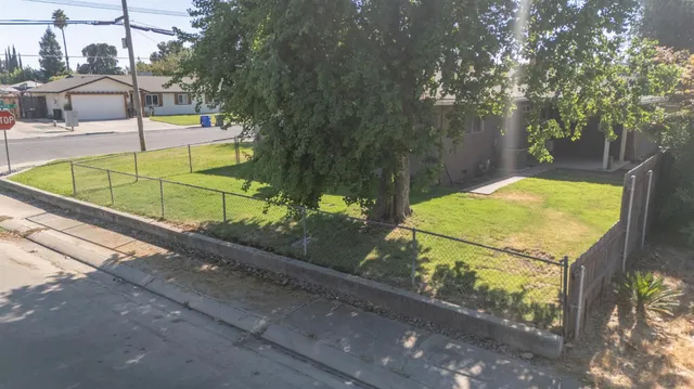 a view of a tennis ground with large trees