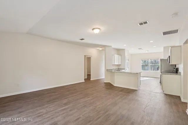 a view of kitchen with refrigerator sink and wooden floor
