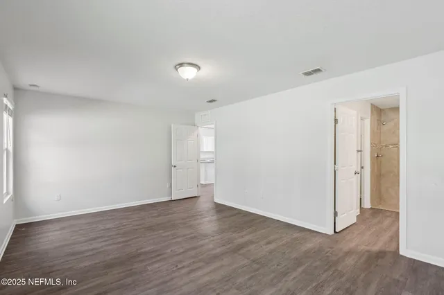 a view of an empty room with wooden floor