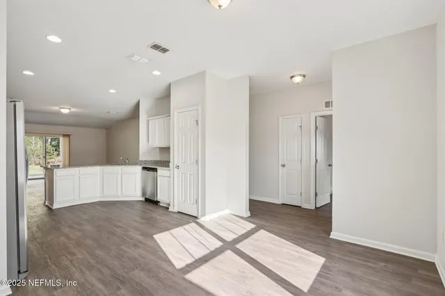 a view of a big room with wooden floor and windows