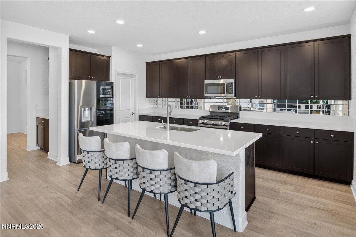 1280 Harness Drive Sparks, NV 89436 - Photo 13 of 46 a kitchen with stainless steel appliances a sink a stove a refrigerator and cabinets