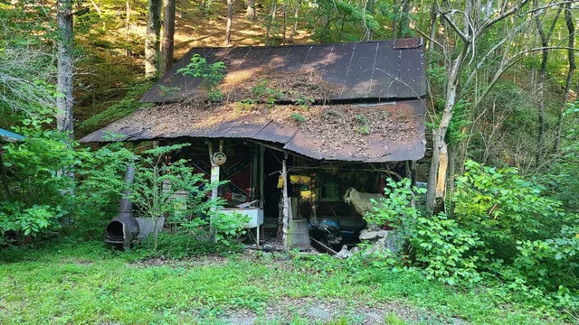 a view of a small house with wooden fence