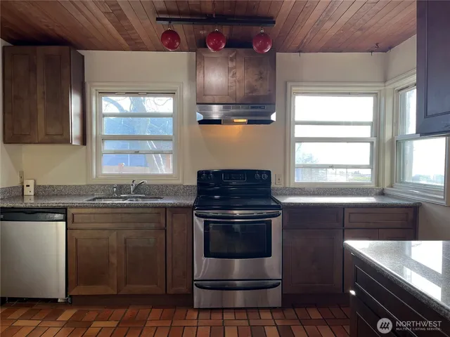 a kitchen with stainless steel appliances granite countertop a stove and a sink