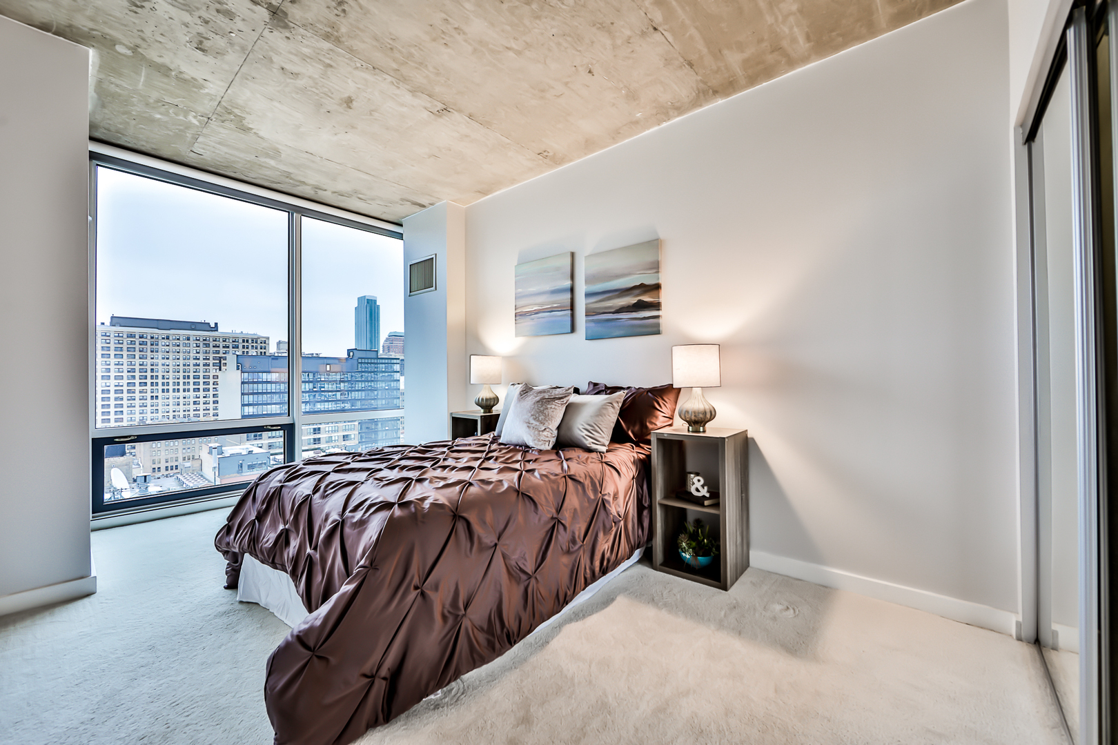 611 South Wells Street, Unit 1903 Chicago, IL 60607 - Photo 18 of 28 a bedroom with a bed and a night stand