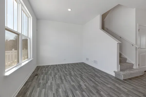 a view of a room with wooden floor and a window