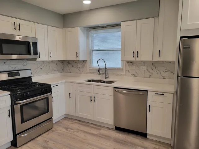 a kitchen with cabinets stainless steel appliances and sink