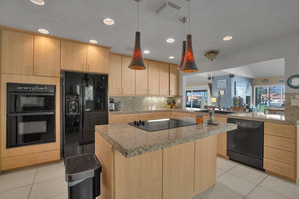 43761 Port Maria Road Bermuda Dunes, CA 92203 - Photo 21 of 50 a kitchen with kitchen island granite countertop a sink and refrigerator