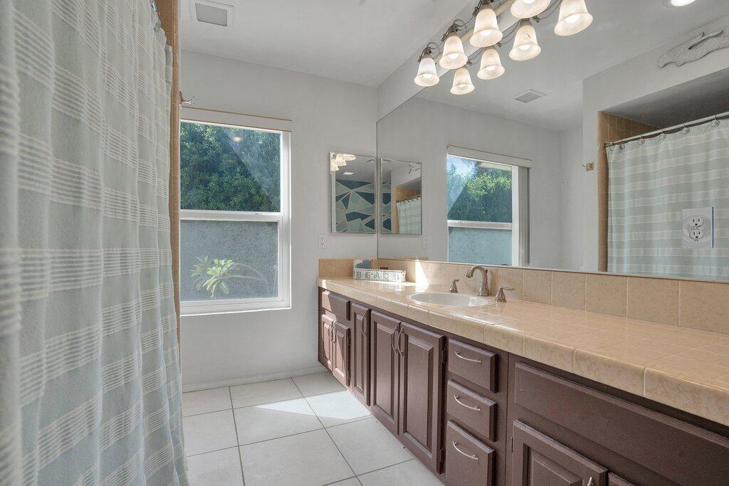 43761 Port Maria Road Bermuda Dunes, CA 92203 - Photo 32 of 50 a spacious bathroom with a granite countertop sink a large mirror and a bathtub