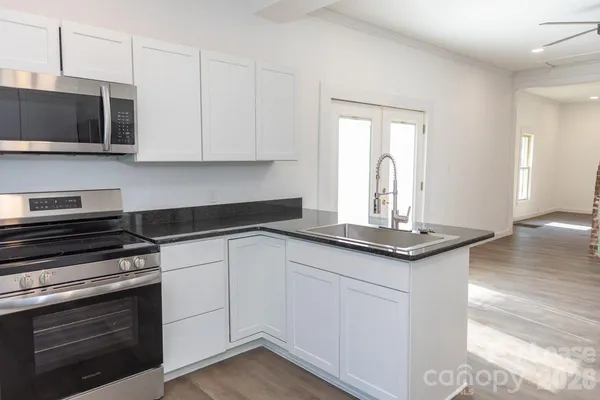 a kitchen with stainless steel appliances granite countertop a sink and a stove