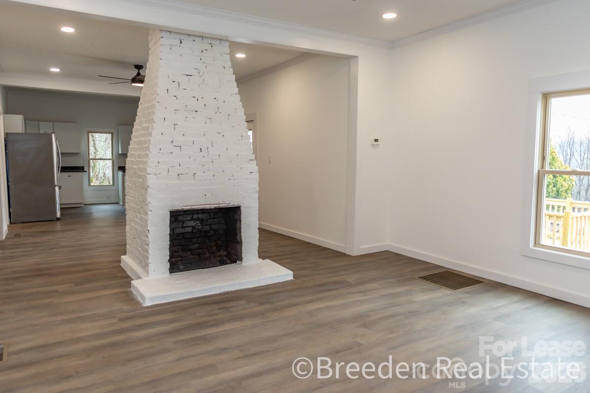 2375 Conley Road Morganton, NC 28655 - Photo 4 of 15 an empty room with wooden floor fireplace and windows