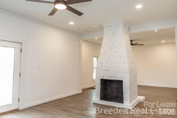 an empty room with a fireplace and fan