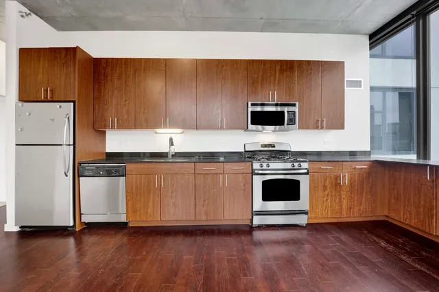 a kitchen with granite countertop wooden floors and stainless steel appliances