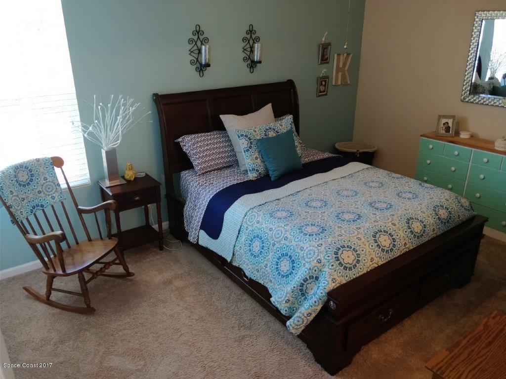 2790 Reston Street, Unit 104 Melbourne, FL 32935 - Photo 18 of 30 a bedroom with a bed a chair and dresser
