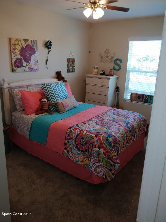 2790 Reston Street, Unit 104 Melbourne, FL 32935 - Photo 22 of 30 a bedroom with a bed and a chandelier