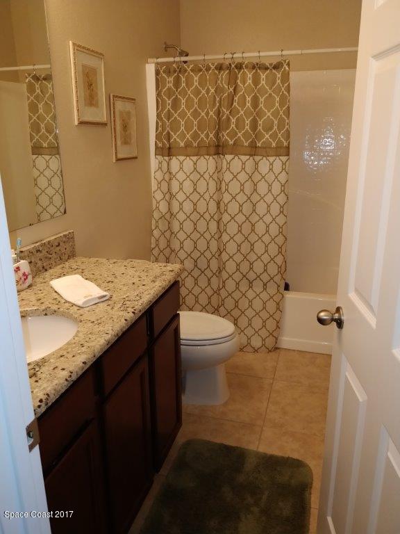 2790 Reston Street, Unit 104 Melbourne, FL 32935 - Photo 29 of 30 a bathroom with a granite countertop sink toilet and shower