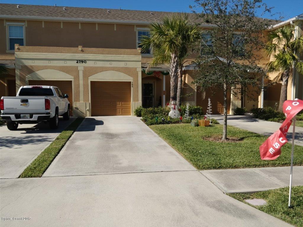 2790 Reston Street, Unit 104 Melbourne, FL 32935 - Photo 6 of 30 a view of a house with a yard and table and chairs under an umbrella