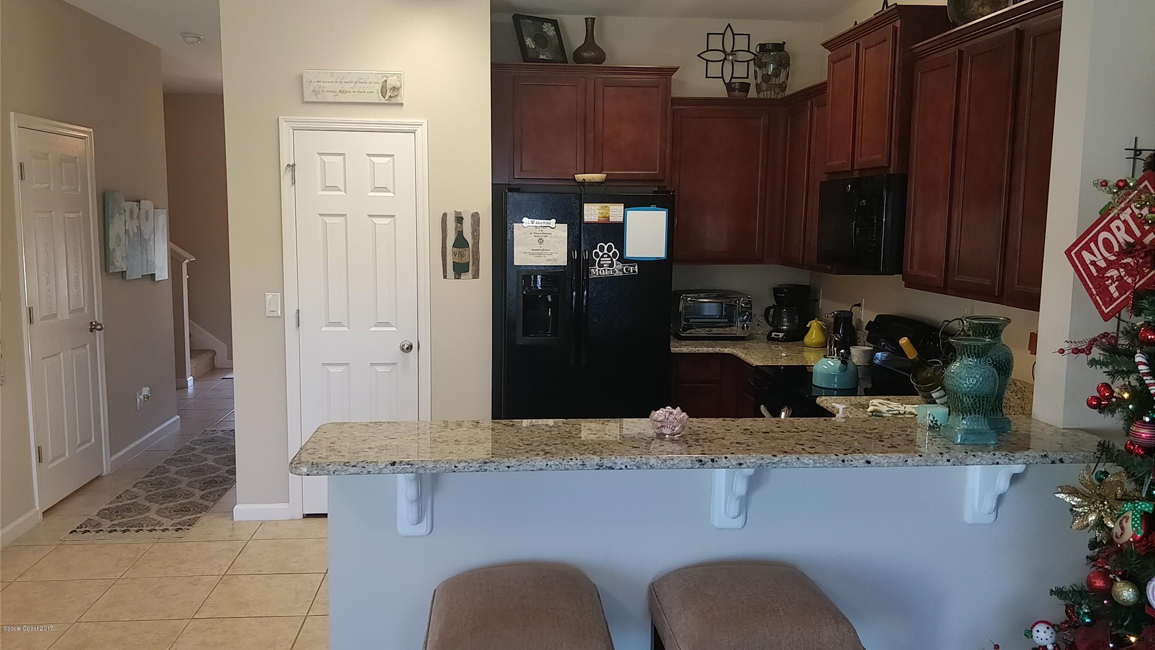 2790 Reston Street, Unit 104 Melbourne, FL 32935 - Photo 9 of 30 a kitchen with granite countertop a refrigerator and a stove top oven