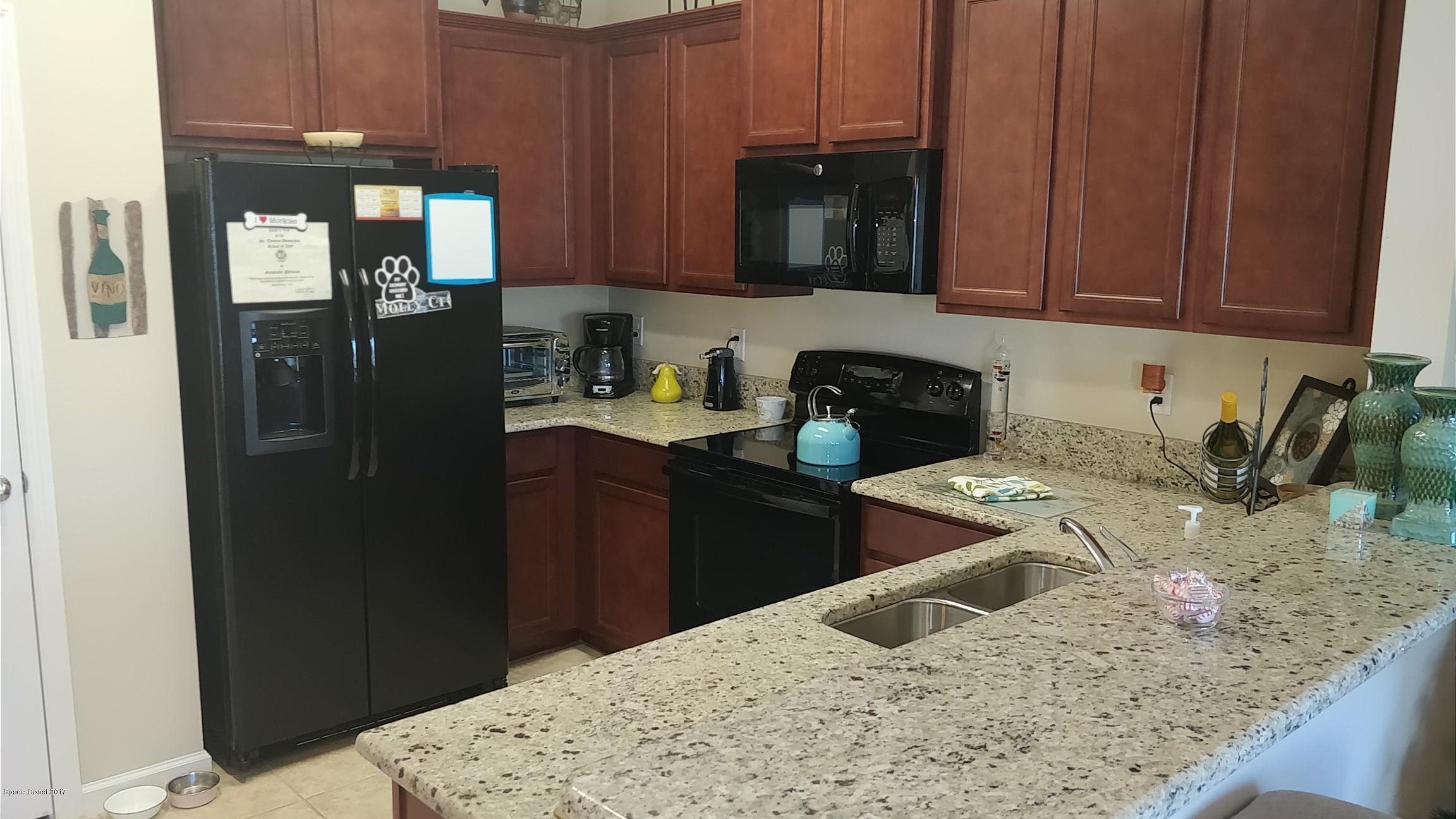 2790 Reston Street, Unit 104 Melbourne, FL 32935 - Photo 10 of 30 a kitchen with a refrigerator sink and cabinets
